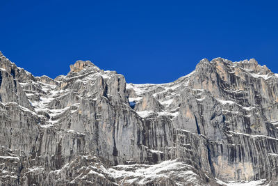 Scenic view of snowcapped mountains against clear blue sky
