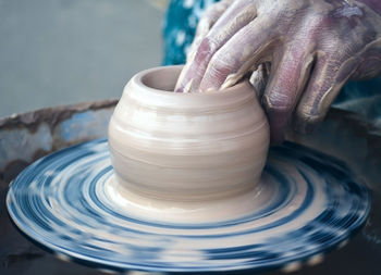 Cropped hand of potter working at workshop