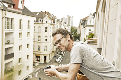 Smiling man on balcony looking down