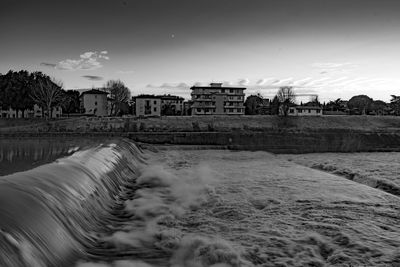 Buildings by sea against sky