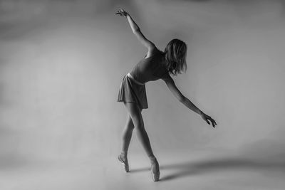 Ballet dancing against gray background