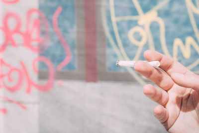 Cropped hand holding cigarette