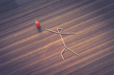 High angle view of toothpicks arranged by strawberry on table