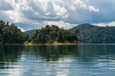 Scenic view of lake by trees against sky