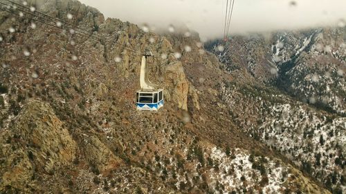 Overhead cable car over rocky mountains during monsoon