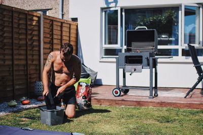 Shirtless man working in yard