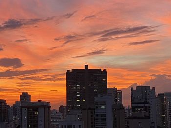 Silhouette buildings against sky during sunset