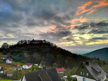 High angle view of houses in town against sky during sunset