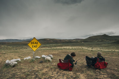 Two men it in camp chairs in the middle of the desert in eastern or.