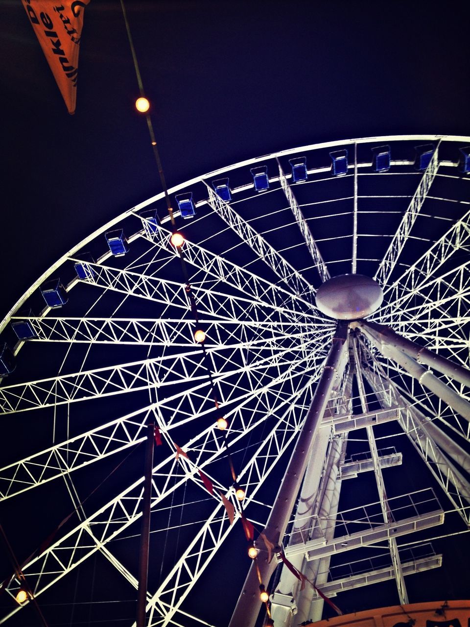 low angle view, amusement park, ferris wheel, amusement park ride, arts culture and entertainment, illuminated, sky, clear sky, built structure, night, fun, outdoors, architecture, no people, tall - high, big wheel, lighting equipment, communication, tower, metal