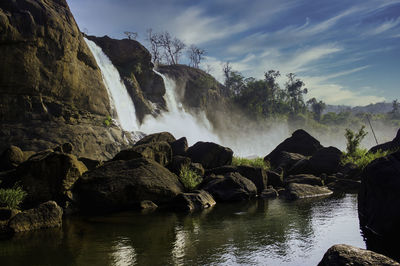 Scenic view of waterfall against sky