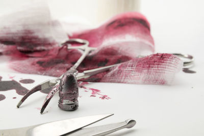 Close-up of surgical equipment and bullet covered in blood