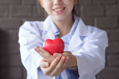 Midsection of woman holding heart