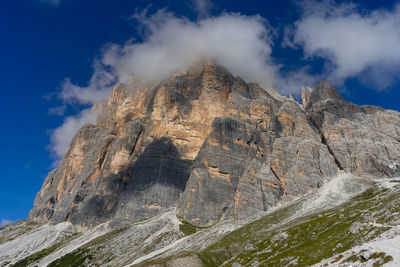 Low angle view of rock formation tofana di rozes against sky