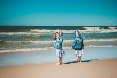 Full length of children on beach against sea