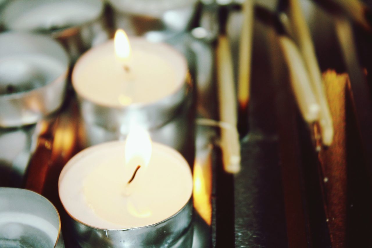 CLOSE-UP OF ILLUMINATED TEA LIGHT CANDLES