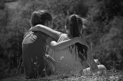 Rear view of girls sitting on field