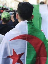Rear view of young man wearing flag