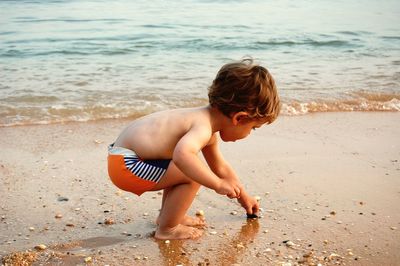 Boy playing on shore at beach