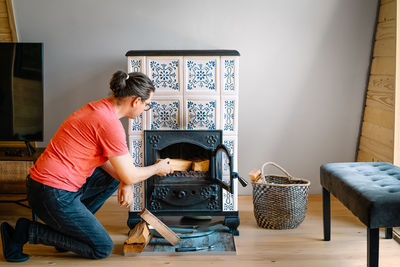 Man preparing fireplace in cabin