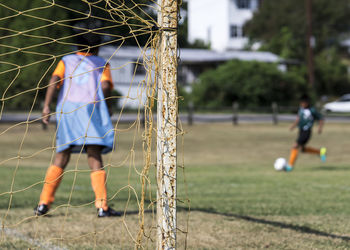 Friends playing soccer on field