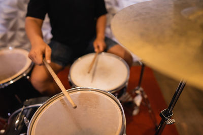 Midsection of man playing drum