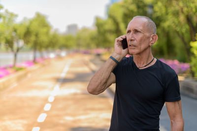 Man using mobile phone while standing on road