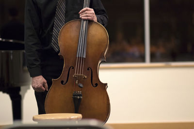 Midsection of man with cello during music concert