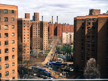 Buildings in city against cloudy sky