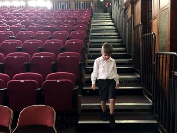 Boy moving down on steps in stage theater