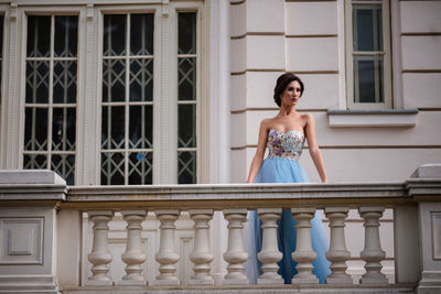 Portrait of woman standing against railing
