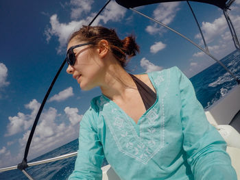 Young woman in boat against sky