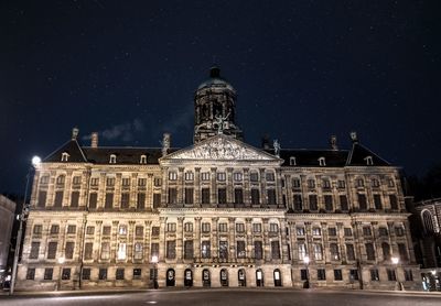 Low angle view of illuminated building against sky at night