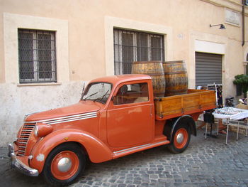 Vintage car parked against brick wall