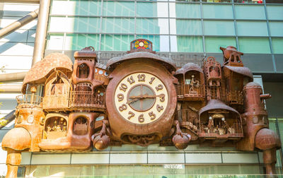 Low angle view of clock tower against building in city