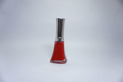 Close-up of glass bottle on table against white background