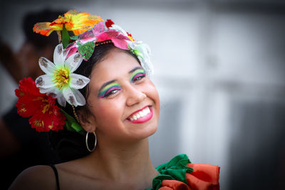 Portrait of smiling young woman with red flower