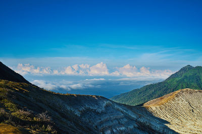 Scenic view of mountains against blue sky