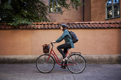 Side view of man riding bicycle on building
