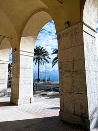 People by sea seen through arch window