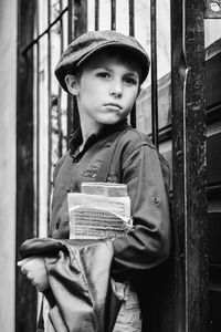 Portrait of young woman standing by window
