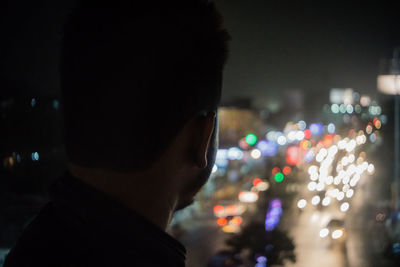 Close-up of man in illuminated city