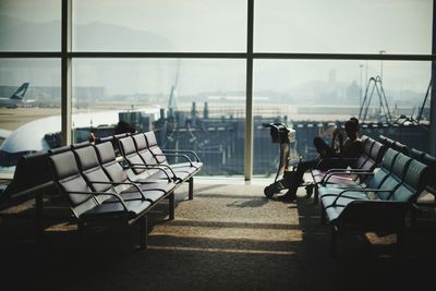 Chairs at airport against sky