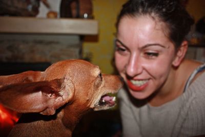 Close-up of dog with woman at home