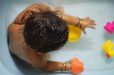 Directly above shot of boy playing with toy in bathtub