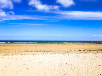 Scenic view of beach against blue sky