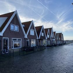 Houses by street against sky in city