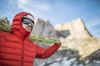 Midsection of woman standing by snow against sky