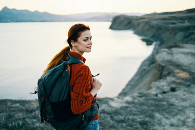 Young woman standing at sea shore