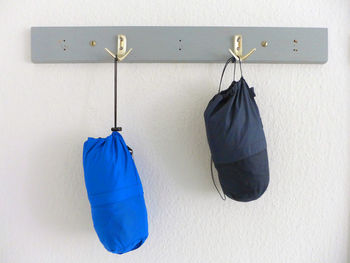 Boxing bags hanging on hooks against wall at home